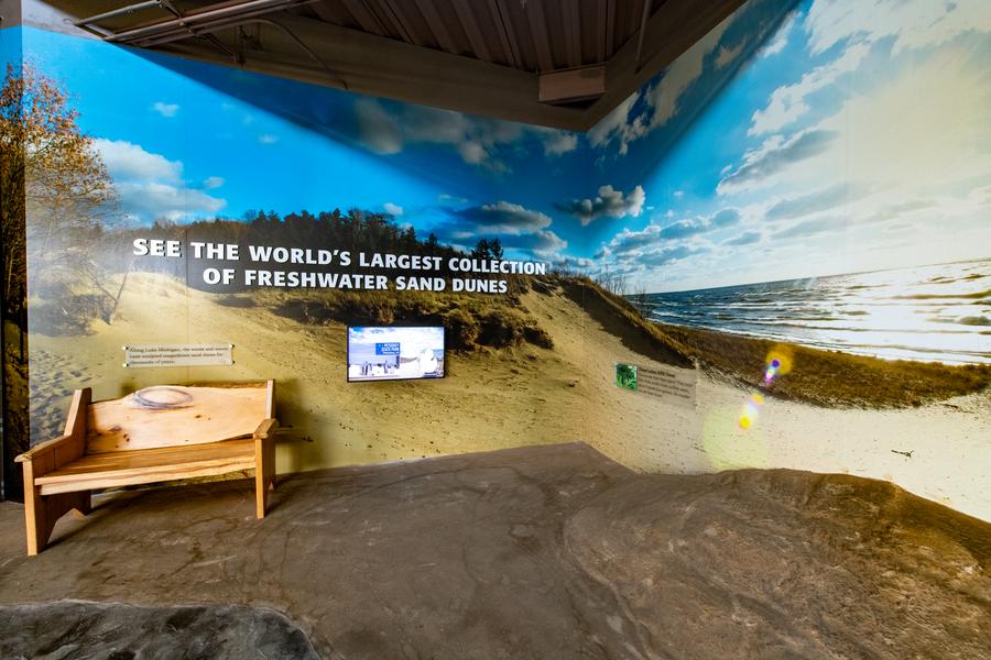 bench with panoramic photo of sand dunes behind it