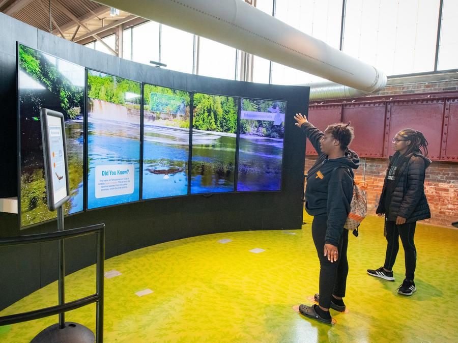 two young ladies try out "fly like an eagle" simulator