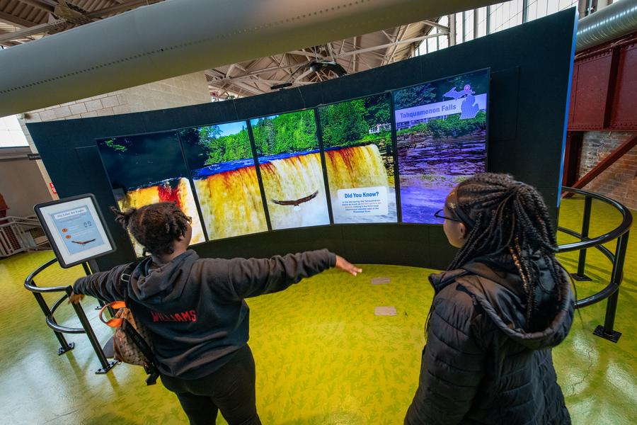 two young ladies try out "fly like an eagle" simulator
