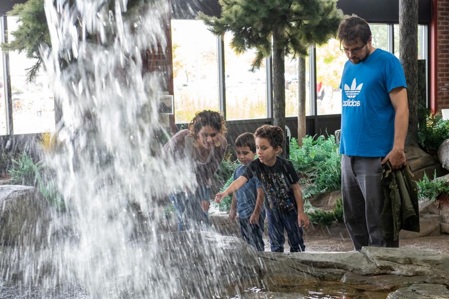 woman, man and two young boys look at OAC waterfall