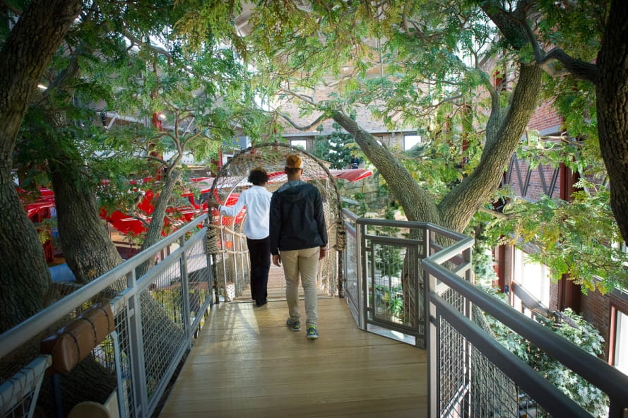 two ladies going onto suspension bridge at the Outdoor Adventure Center