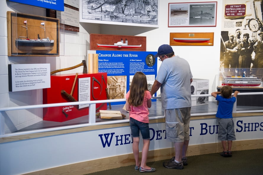 Man and kids learn about Detroit River shipbuilding history in Outdoor Adventure Center exhibit