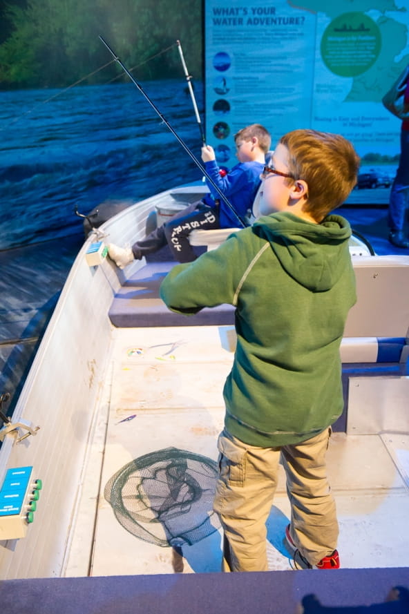 boy tries out fishing simulator at Outdoor Adventure Center