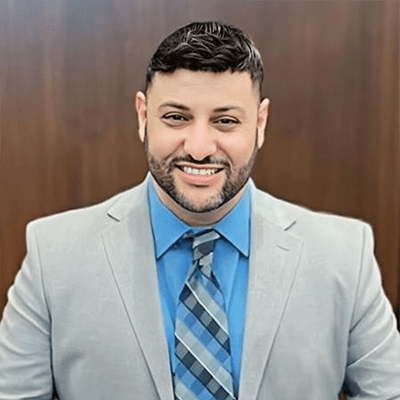 Tareq Ramadan smiling in a jacket and tie
