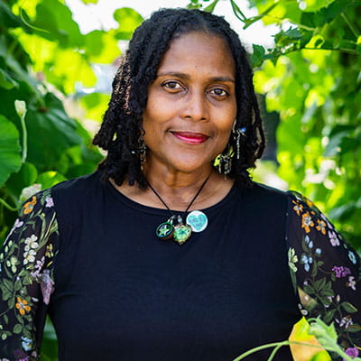 Angela outside surrounded by foliage