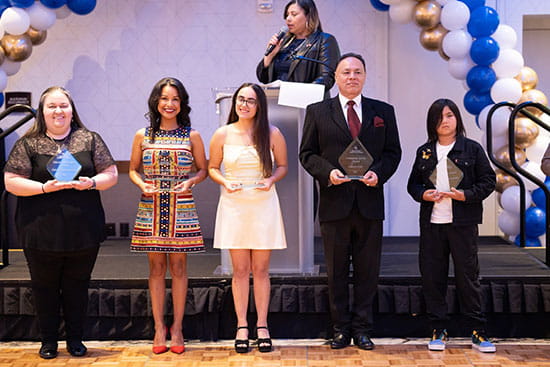 2025 Hispanic Heritage Award recipients stand in front of stage at gala