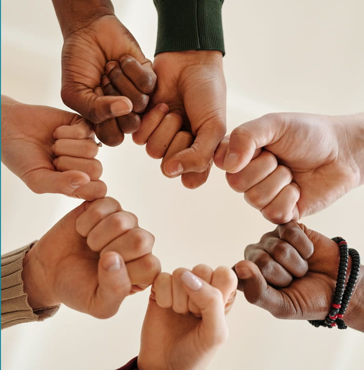 Volunteers Needed with diverse fists together forming a circle