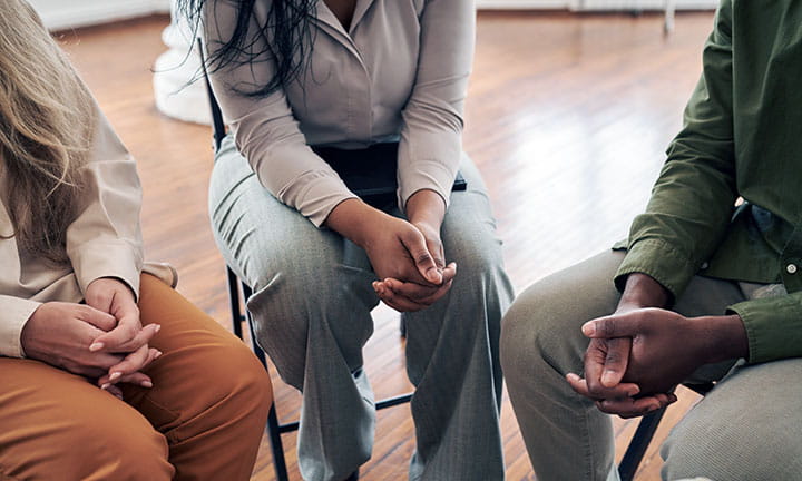three people sitting in a sharing circle