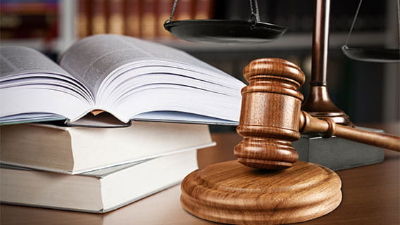 law books stacked on a table with a gavel beside them
