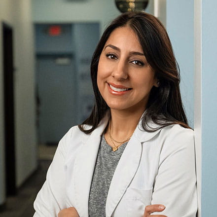 smiling woman in a lab coat in a health care setting