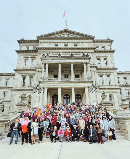 A large group of people posing at the steps of the capitol during AANHPI Day 2024