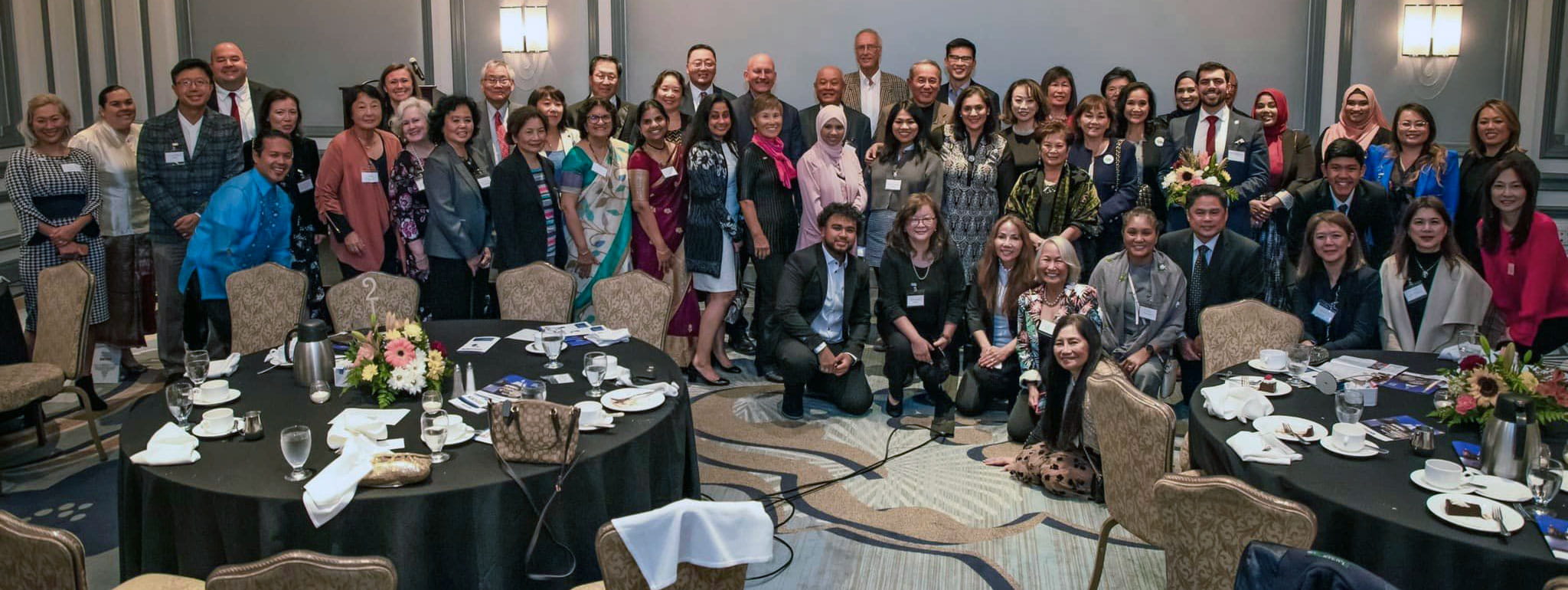 A group of more than twenty MAPAAC members and partners posing for a picture in a conference hall