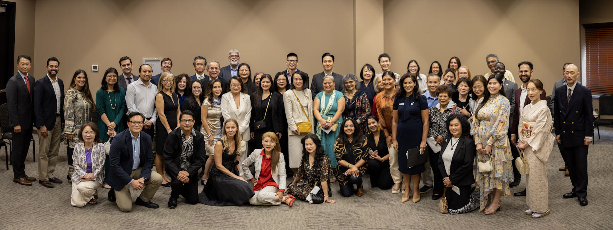 A group of more than twenty MAPAAC members and partners posing for a picture in a conference hall