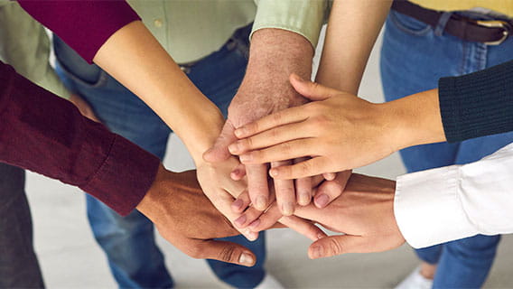 The hands of six people stacked