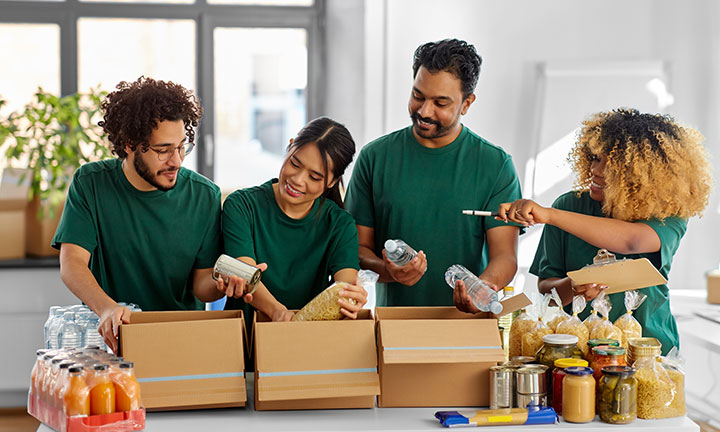 Four volunteers preparing food boxes
