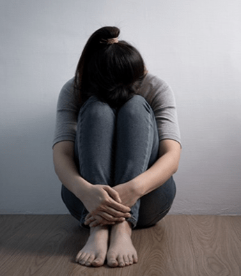 Sad Lady sitting on Floor with arms crossed legs