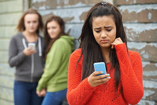 Young teen girl being cyberbullied on social media