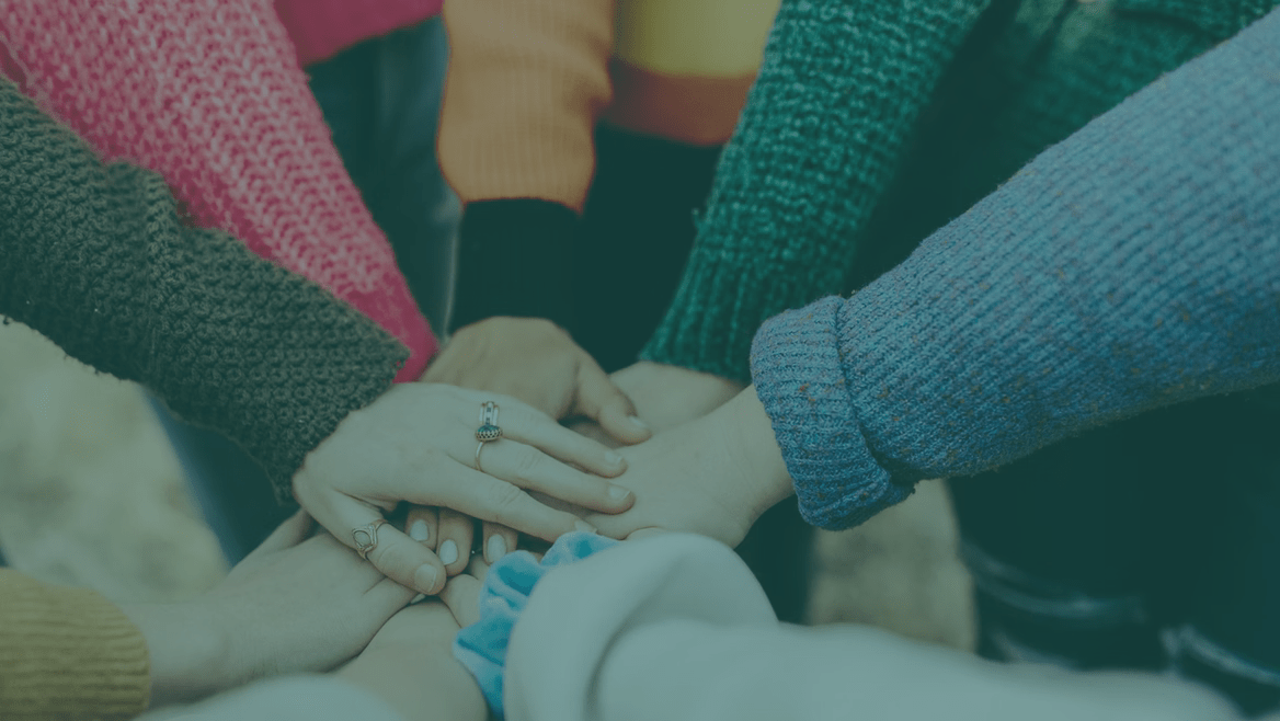Multiple hands coming together in a show of unity