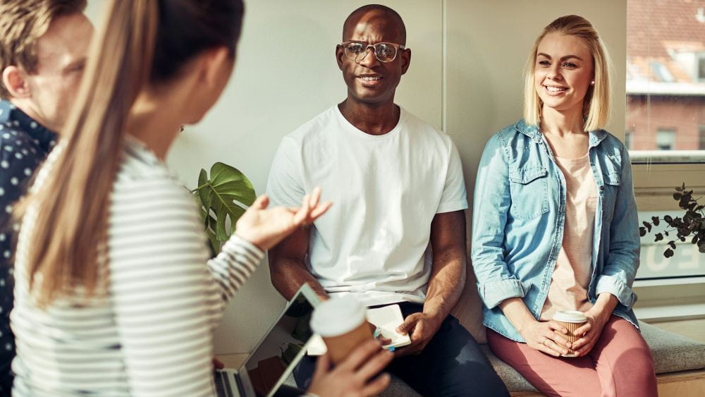 A small group of adults talking and listening intently