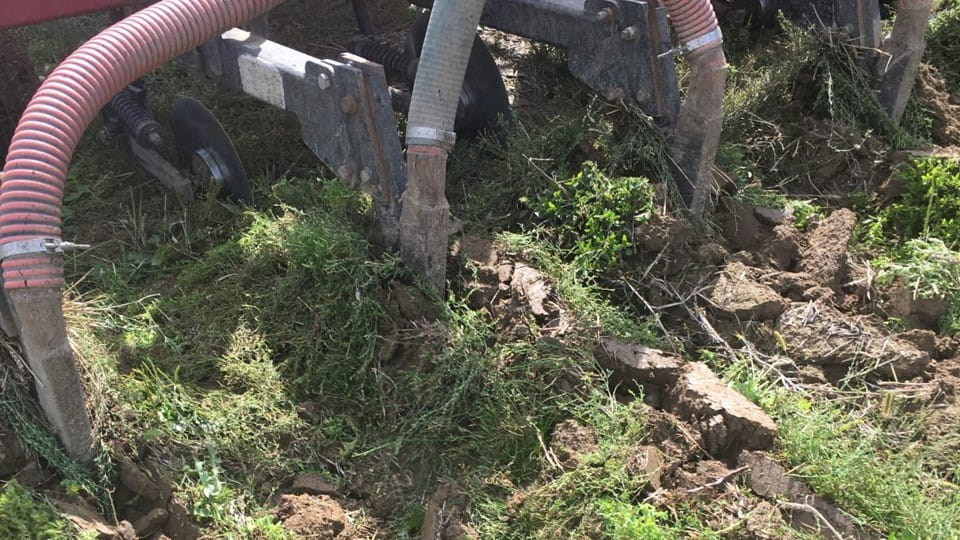 A large machine resting on dirt and grass, used to inject biosolids underground