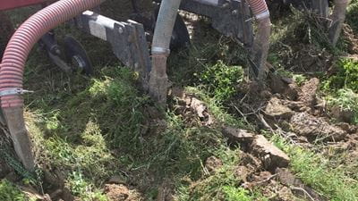 A large machine resting on dirt and grass, used to inject biosolids underground