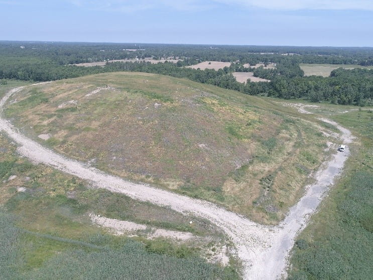 a large grassy hill, which is actually a landfill