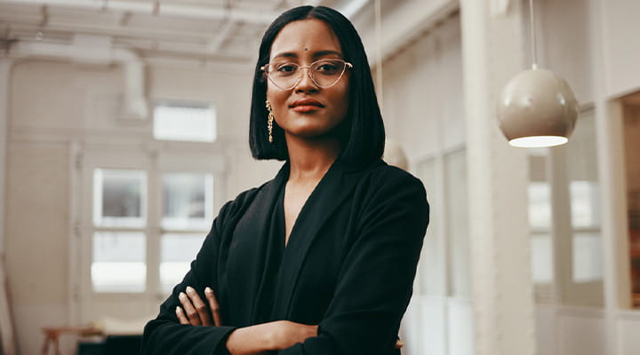 Woman with arms crossed looking towards the camera. 
