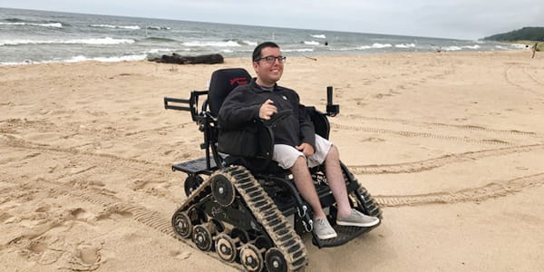 A person using a track chair on the beach at Muskegon State Park