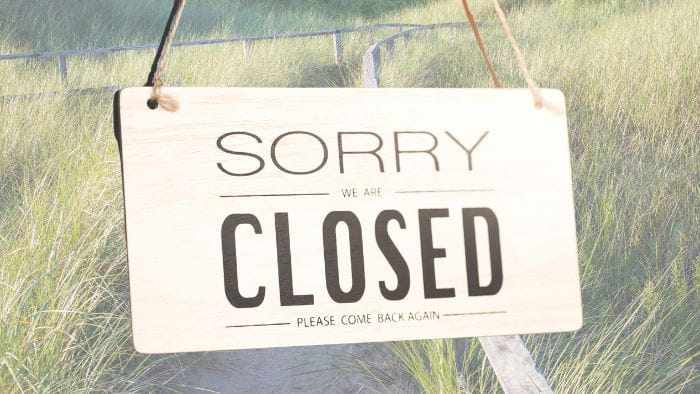 A sorry we are closed, please come back again sign with dune trail in background
