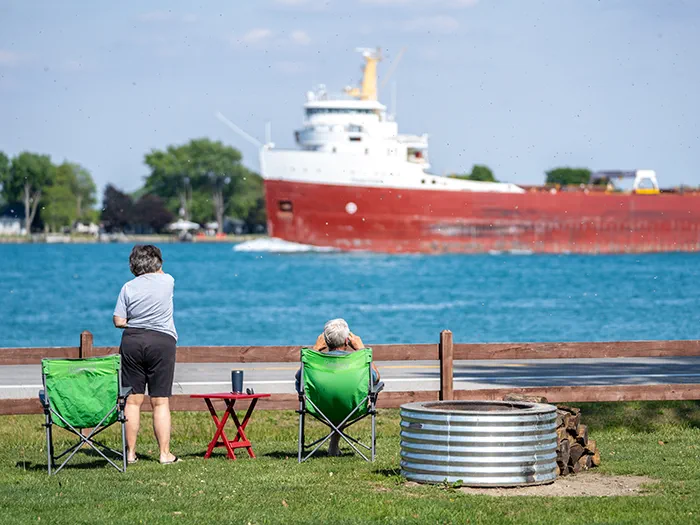 two visitors looking at freighters with binoculars