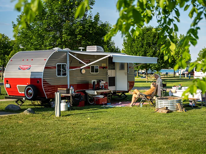 two visitors sitting with retro camper