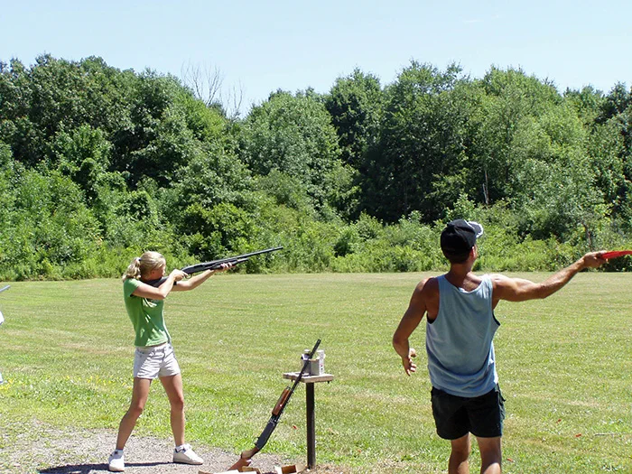 woman shooting rifle at shooting range