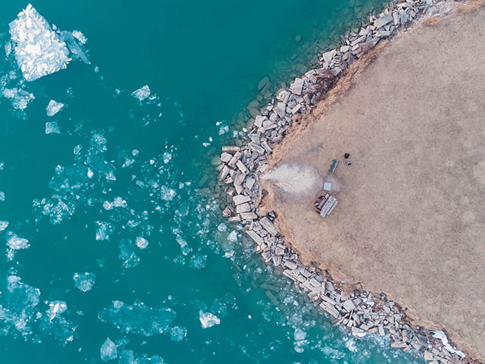 birds eye view of island and water with ice