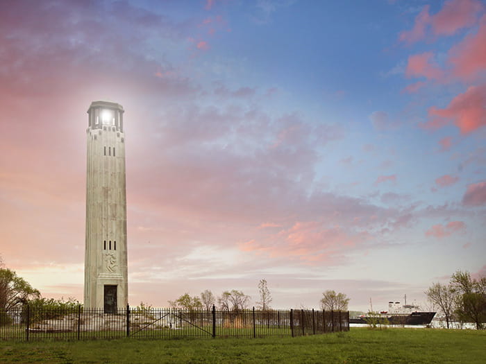 lighthouse with ship in background