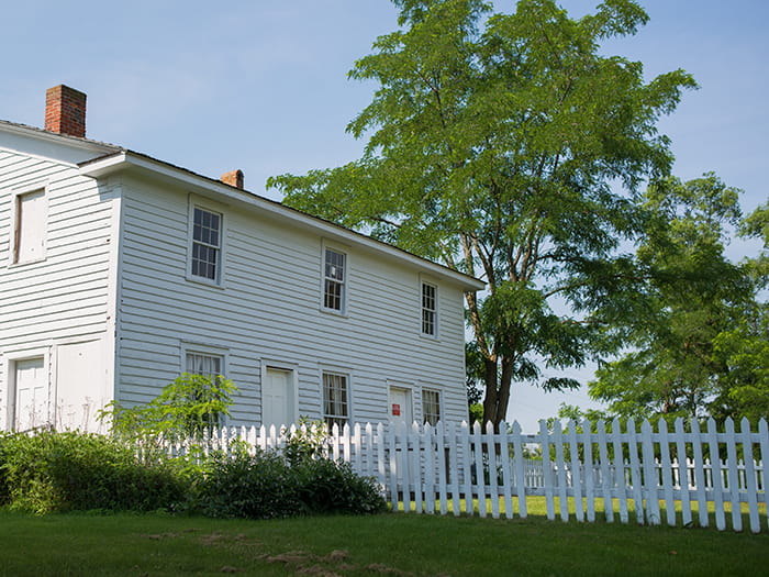 white historic building with picket fence
