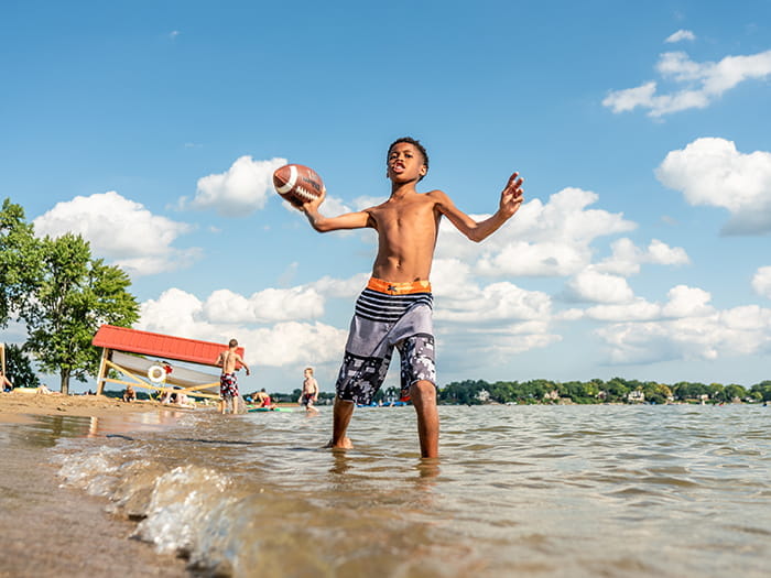 boy throwing football in water