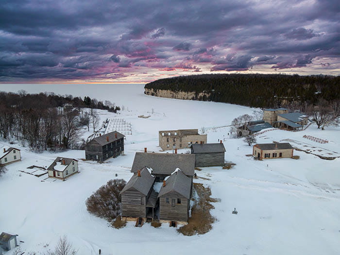 Snow covered historic village and cliffs