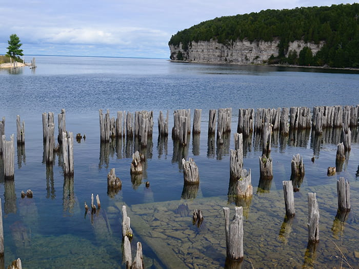 cliffs with water and old wooden posts