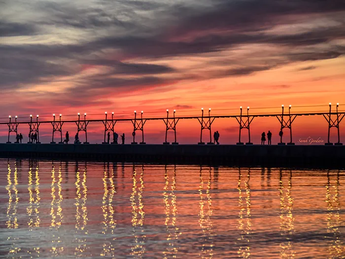 sunset behind pier photo by Sarah Goodwin