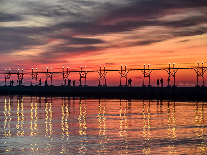 sunset behind pier photo by Sarah Goodwin