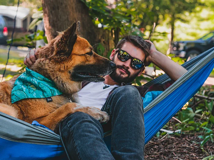 Man and dog sitting in hammock