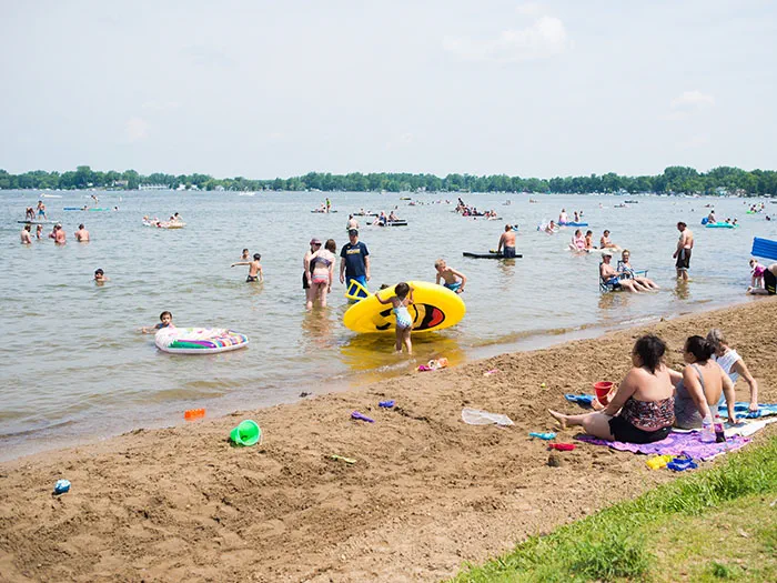 kids and adults playing in water and sitting on beach