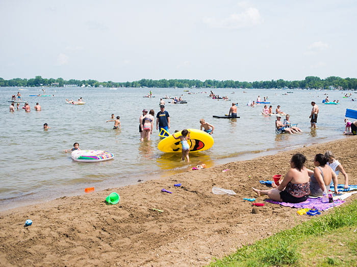kids and adults playing in water and sitting on beach