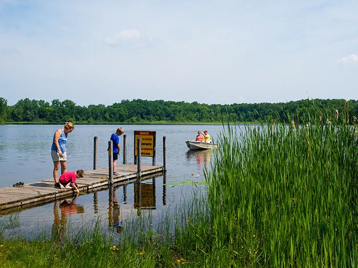family on skid pier with paddlers in background
