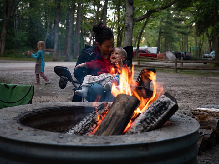 mother and child snuggling next to the campfire