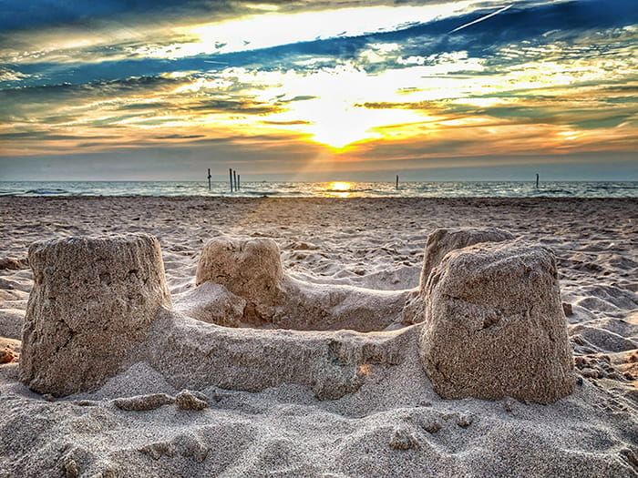 sandcastles on beach with colorful sky