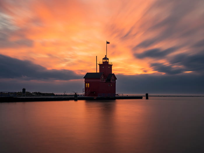 big red lighthouse with red sky