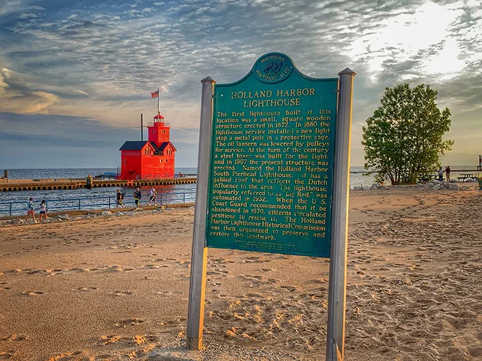 historic sign with big red lighthouse in background