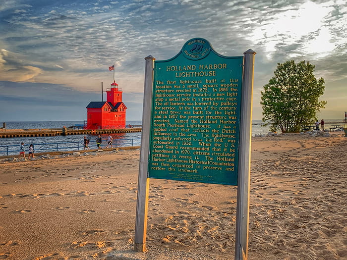 historic sign with big red lighthouse in background