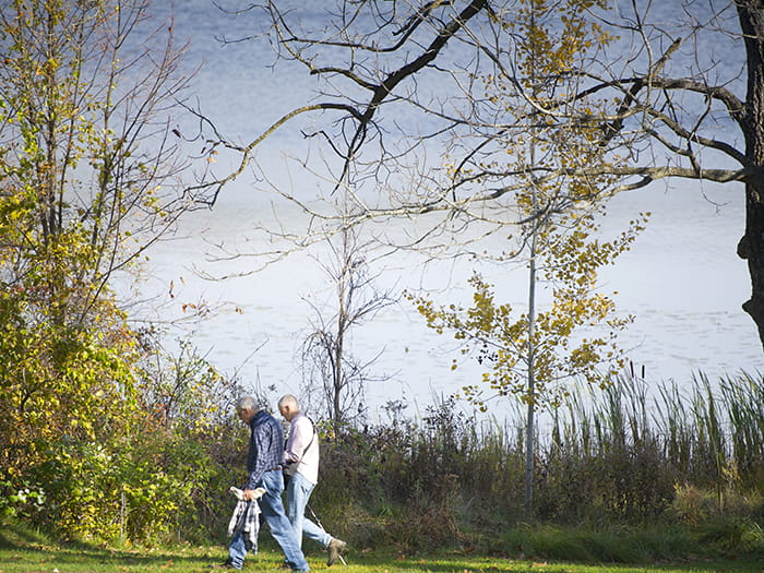 two men walking along lake